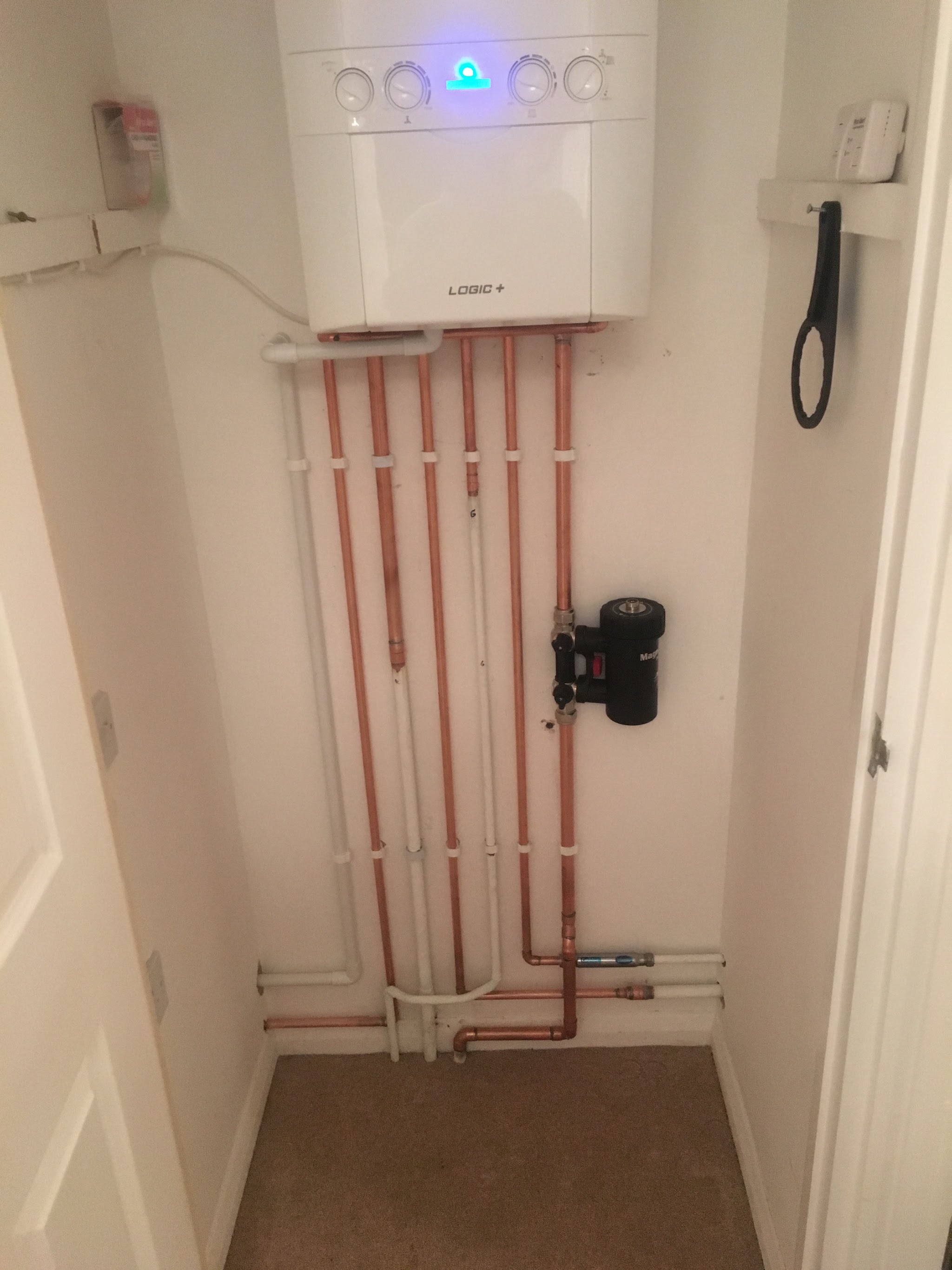 New wall-hung boiler and copper pipework fitted in a cupboard